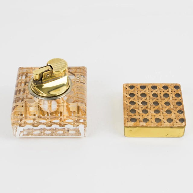 This lovely 1970s smoking desk set features a lighter and a box in crystal clear Lucite with real cane-work or rattan...