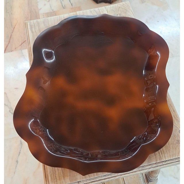 Beautiful Bakelite trays. One is brown and the other is clear with a glazed finish. They have a slightly wavy shape around...