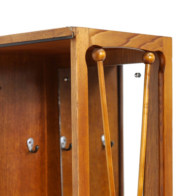 This vintage mid-century armoire was produced in England during the 1950s. The right side features a vanity mirror with...