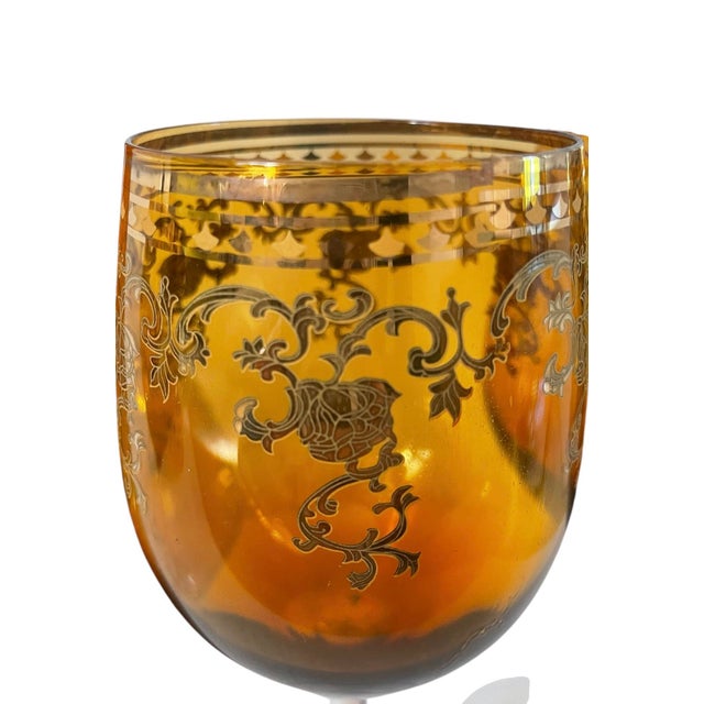 This vintage amber and gold gilt Bohemian decanter and four wine glasses set exudes mid-20th-century modern style with its...