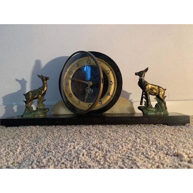 A clock to be placed centrally on a chest of drawers or chimney in art deco marble, bronze and brass, 1930s. Made of stone...