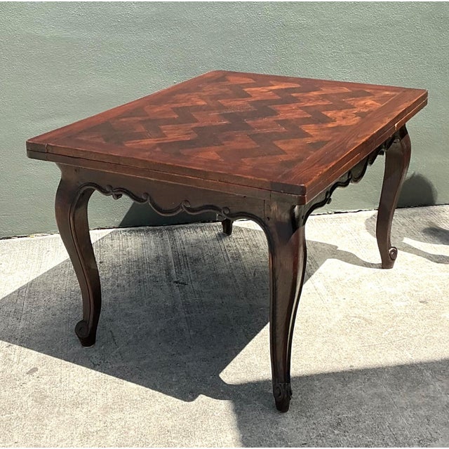 Beautifully crafted with timeless elegance, this vintage extendable dining table showcases an eye-catching herringbone...