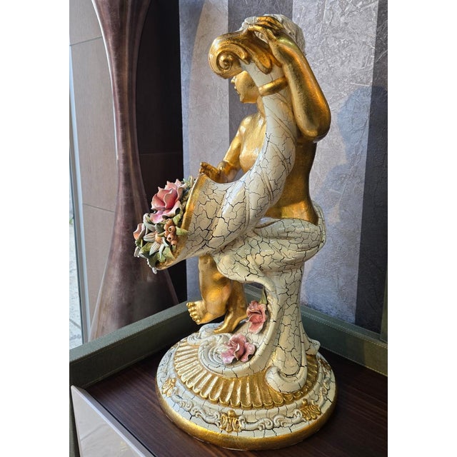 Handcrafted ceramic cherub sculpture by Lorenzon, made entirely in Italy. The seated figure features a rich 24K gold...