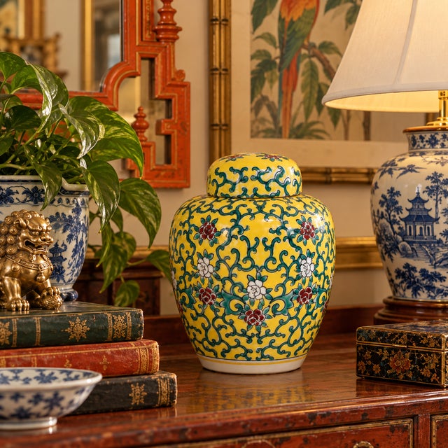 A vintage porcelain ginger jar, hand decorated with green vines and flowers on a yellow field. Good condition.
