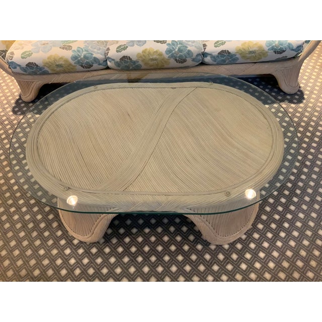 Oval bamboo with glass top coffee table. Has no marks, but in the style of Ficks Reed. Base measures 27x41