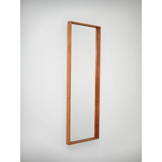 Swedish mirror from the 1960s attributed to Arne Wahl Iversen, featuring a slender rectangular structure and a refined...