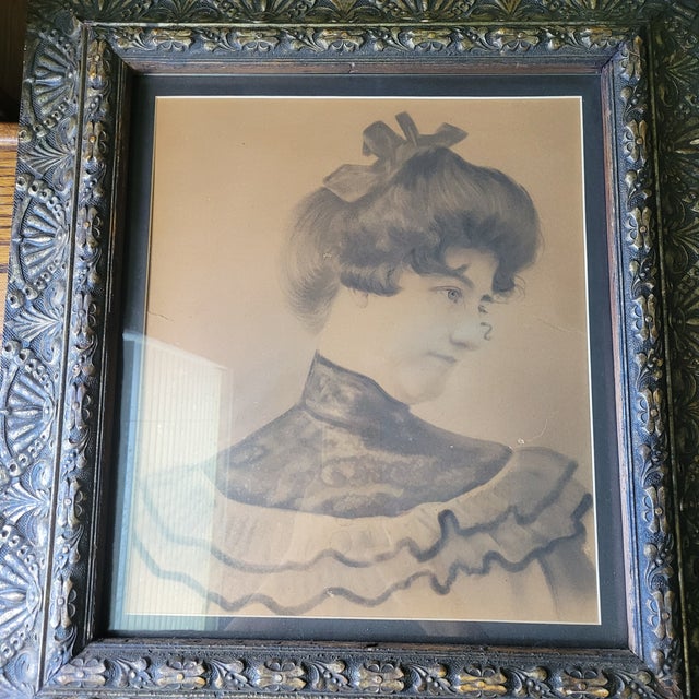 This antique portrait of a woman features a muted palette in an ornate frame with matting. The large print showcases a...