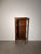 An elegant display cabinet featuring a warm brown wood finish, glazed front and sides, and decorative gold-tone metal...