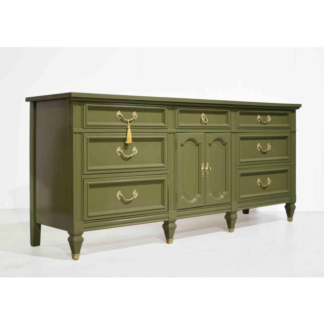 Freshly updated and full of charm, this Mid Century French-Inspired Sideboard with Louis XV Brass Hardware by Dixie offers...