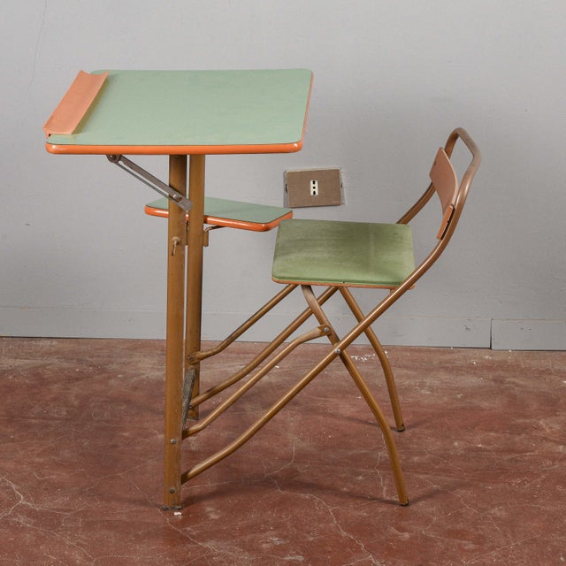 This vintage folding school desk is an example of functional design from years gone by, characterized by a playful and...
