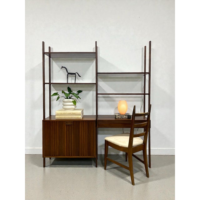 Vintage two bay wall unit. Features a large open cabinet, a small one drawer desk, and four shelves. This piece has been...