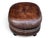 This vintage oval ottoman is upholstered in rich brown leather with a naturally aged patina that gives it warmth and...