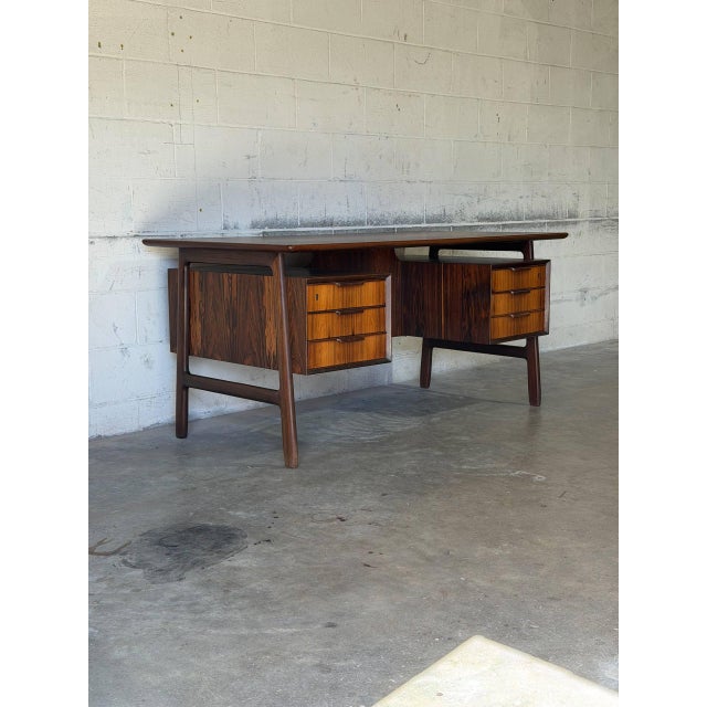 This freestanding executive desk features a floating top supported by an elegant leg structure with dual drawer pedestals....