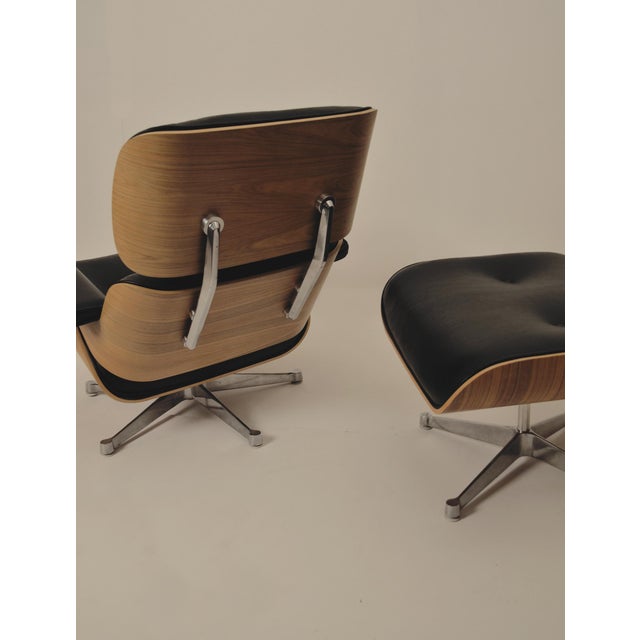Set consisting of an eames lounge chair and ottoman. Upholstered in black leather and walnut. Likely made after 1989, as...