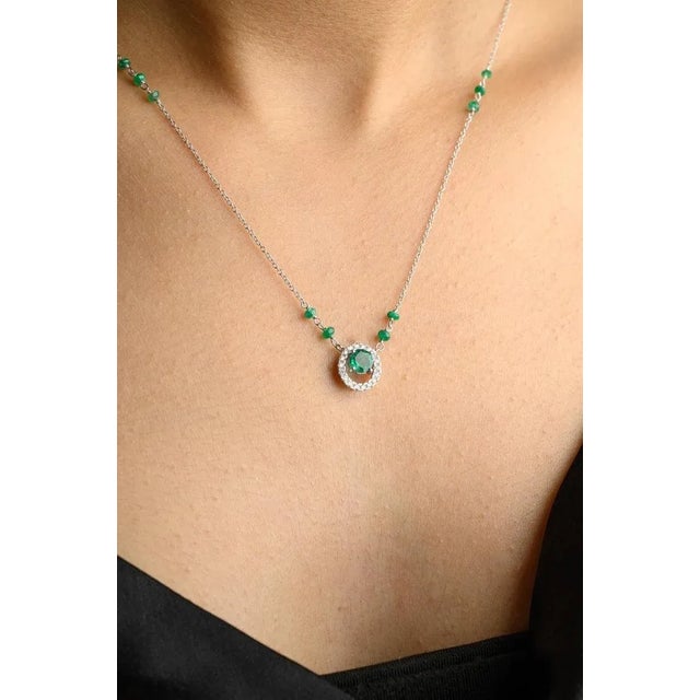 Everyday Emerald and Diamond Necklace with Chain in 18K Gold studded with round cut emerald and round cut diamonds. This...