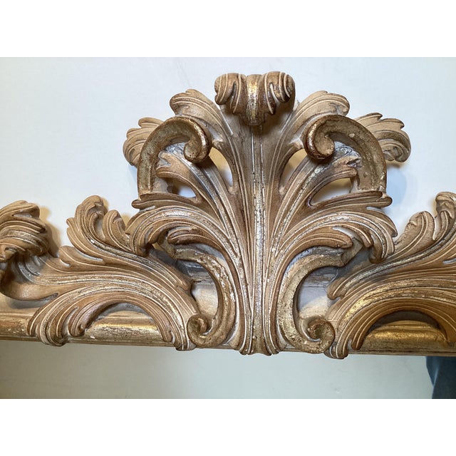 Hand carved Rococo style wood mirror. The wood frame with a light wash of gilding with mostly wood showing through. The...