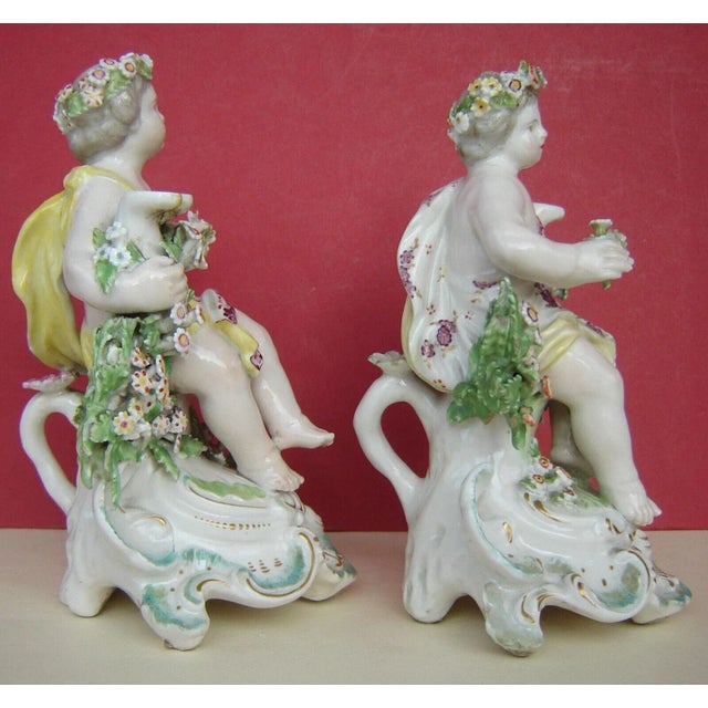 Pair of Derby porcelain cherub figures originally designed as candlesticks but now lacking sconces. Each cherub posed atop...