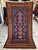 This exquisite hand-knotted wool area rug showcases a traditional Baluchi prayer rug layout featuring a unique Tree of...