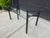 Sleek vintage postmodern dining table featuring a thick rectangular glass top paired with a sculptural black metal tubular...