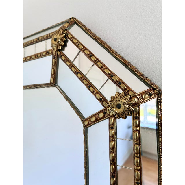 A large vintage Spanish Venetian-style beveled wall mirror, dating to the 1980s. The mirror has a decorative glass frame...