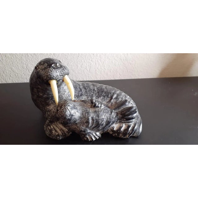 It is Canadian Wolf Sculptures Slate Walrus & Baby Sculpture. Highly collectible & great decor piece. Procured at an...