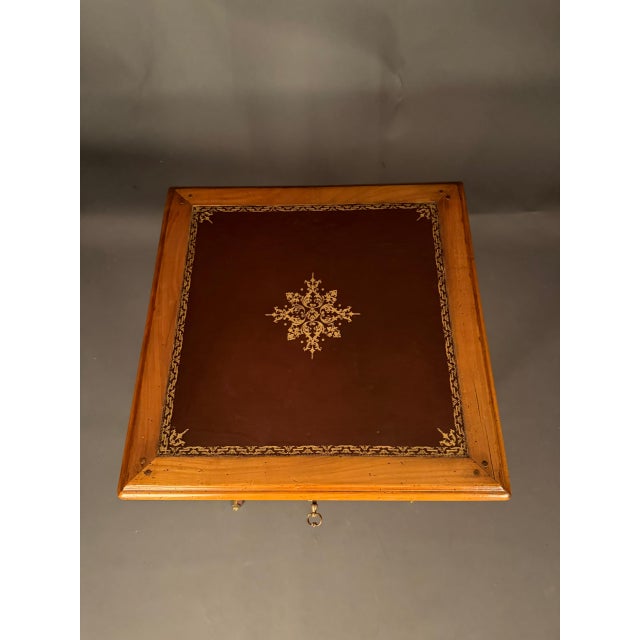 Elegant French Louis XV style side table dating to circa 1920, crafted in cherry wood and topped with leather. The square-...