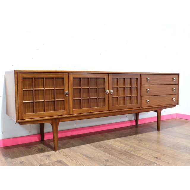 Discover a gorgeous mid century sideboard in the style of British furniture maker Younger, a standout piece available at...
