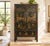 A tall Chinese armoire in black lacquer, painted across both doors with a landscape of pagodas, arched bridges, willows...