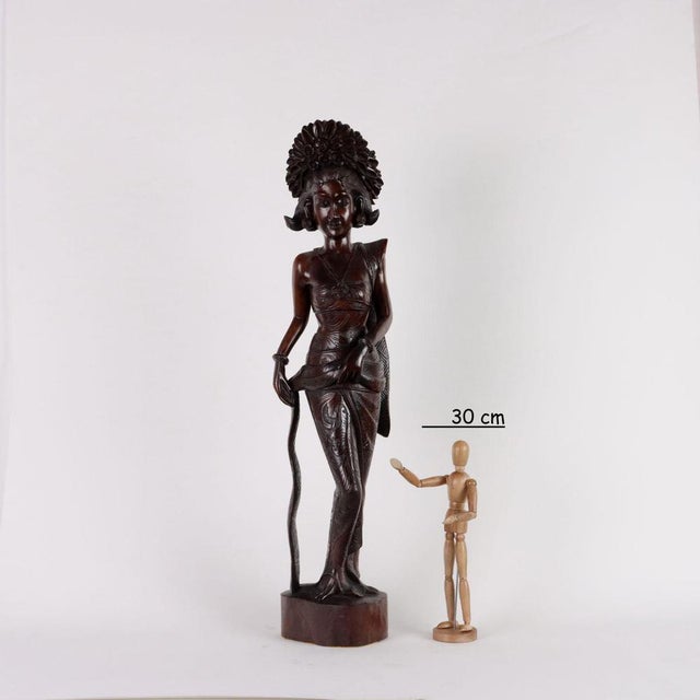 Carved wooden sculpture depicting a female figure. This piece is attributed to the mentioned designer/maker. It has no...