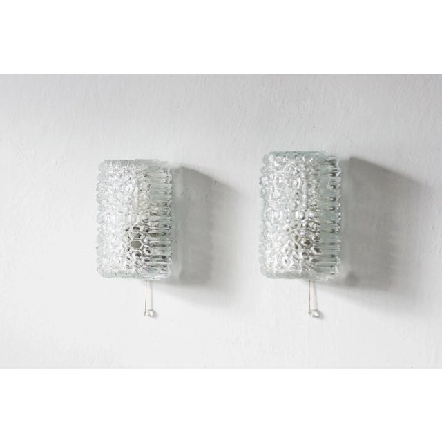 A set of two wall lamps manufactured by the renowned german manufacturer glashütte limburg, known for its perfect...