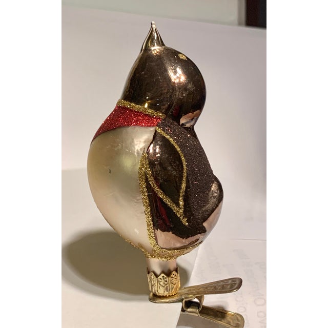Beautiful old world glass blown songbird ornament in shades of silver and brown with a red breast and completed with gold...