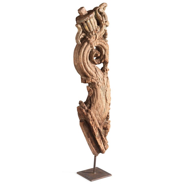 A striking carved wooden fragment showcasing a stylised yali—the mythological guardian figure central to South Indian...