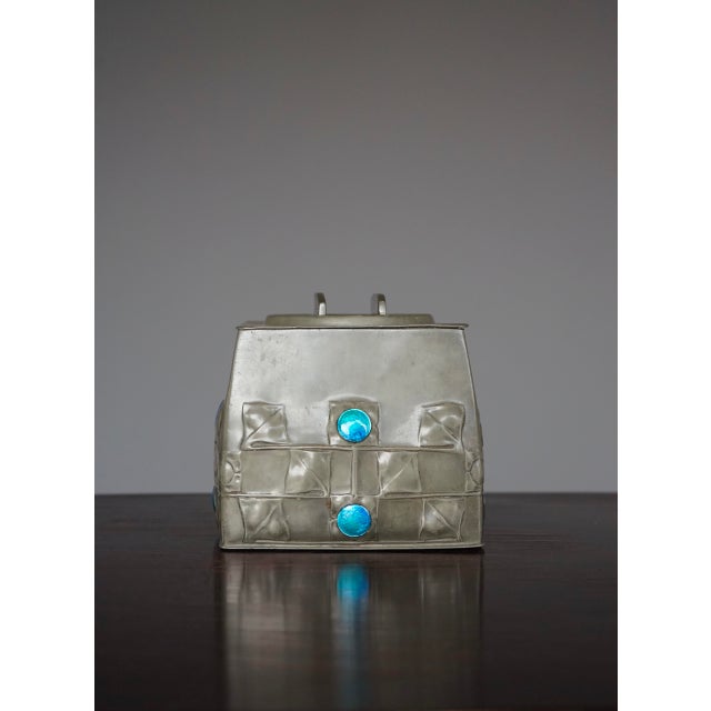 A rare pewter biscuit container with enamel inserts. Designed by Isle of Man designer Archibald Knox Liberty & Co of...