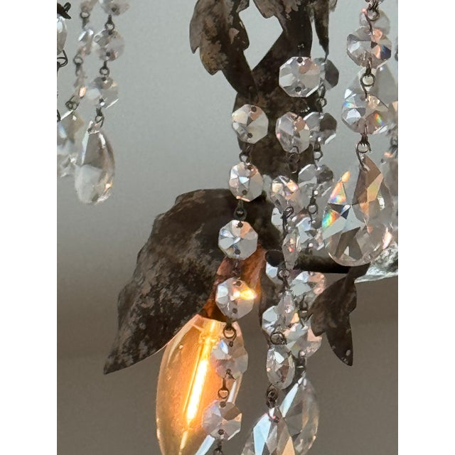 Elegant wrought iron chandelier has a rustic silver and bronze finish with a leaf and bud design. This light fixture is...