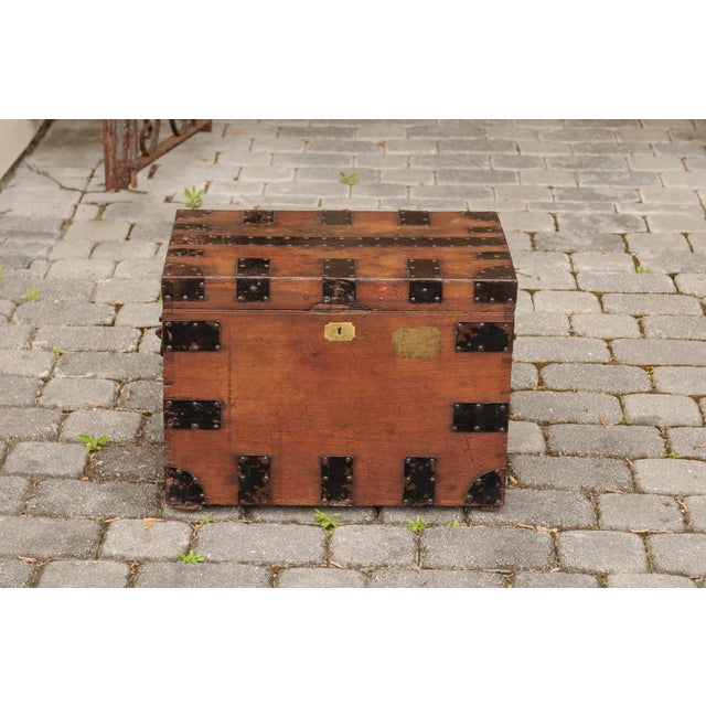 An English Victorian period oak trunk from the late 19th century, with metal accents and lateral handles. Born in England...