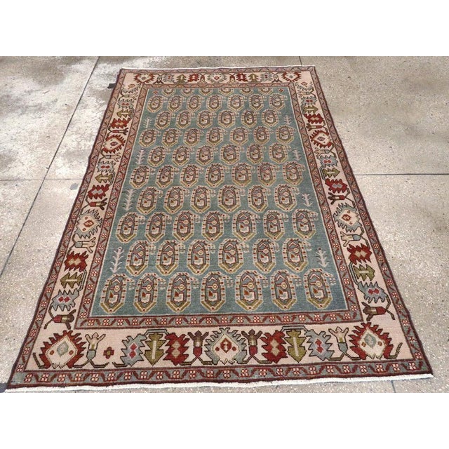 This mid-20th-century Persian Malayer accent rug presents a tightly organized allover design across a muted blue field....