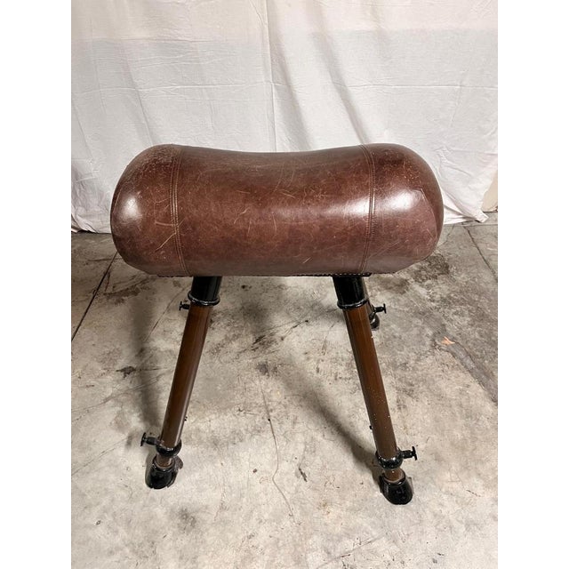 A leather and metal gymnastic horse made in the 1940s and 1950s. This piece of exercise equipment features a padded upper...