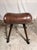 A leather and metal gymnastic horse made in the 1940s and 1950s. This piece of exercise equipment features a padded upper...