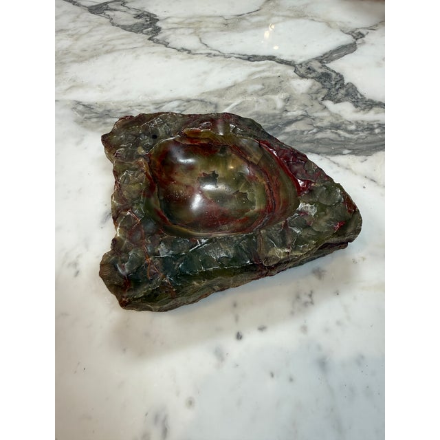 Hand-carved marble ashtray featuring rich burgundy, forest green, amber, and smoky gray tones. The polished bowl contrasts...