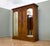 An impressive circa 1900 triple wardrobe in warm-toned walnut, featuring two arched mirrored doors, a richly carved...