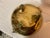 This is a heavy brass footed cauldron with beautiful patina and gnome-like faces that hold the two handles on either side....