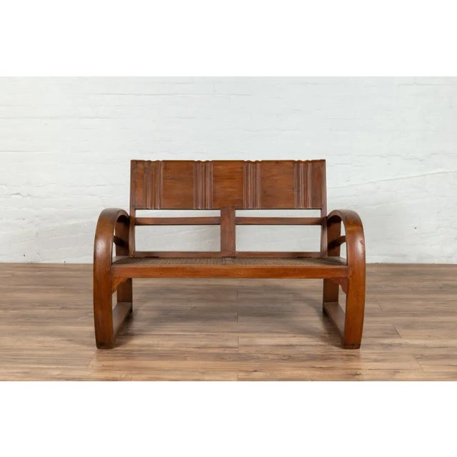 Early 20th Century Teak Wood Settee from Madura with Folding Back, Looping Arms and Cane Seat For Sale - Image 5 of 13