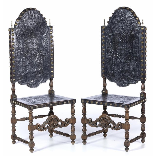 Pair of high-backed chairs portuguese, 19th century, in carved and turned chestnut wood, seats and backs in tooled leather...