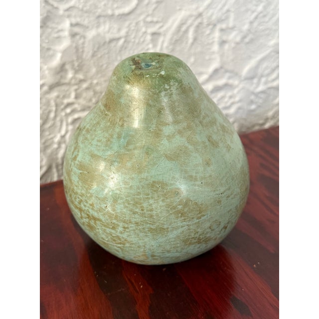 Decorative metal pear with the look of verdigris over copper. Simple and sculptural, it sits nicely on a stack of books, a...
