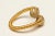 An exceptional ring of two crossed and twisted 18K gold bands ending with balls of round, brilliant cut, pave`-set...