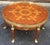 An elegant French Empire round coffee table has beautiful inlaid marquetry with legs of classical caryatids with brass...