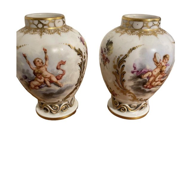 Pair of Putti Vases from Königliche Porzellan-Manufaktur (KPM). Featuring motifs of putti, floral decorations, and...