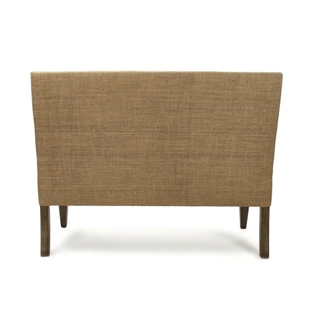 An elegant bench style sofa in a natural linen fabric with bronze studs outlining the sofa. This bench has a jute back and...