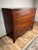 An exceptional and increasingly rare Federal period cherry chest of drawers bearing the original printed cabinetmaker’s...