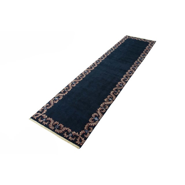 This hand-knotted Kashan runner measures 380 x 97 cm and impresses with its simple elegance. The deep dark blue field is...